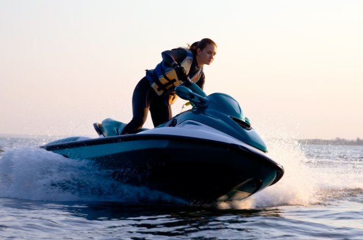 Une personne conduit une motomarine sur l'eau pendant le jour.
