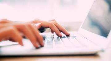 Doigts qui touchent un clavier et qui tapent les mots « signalez un crime ».